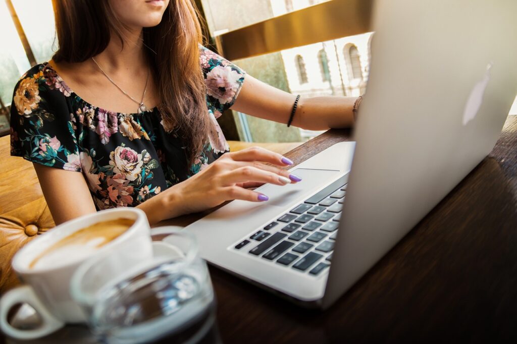 Frau arbeitet am Laptop im Cafe Pinterest SEO für Anfänger Darauf achten!