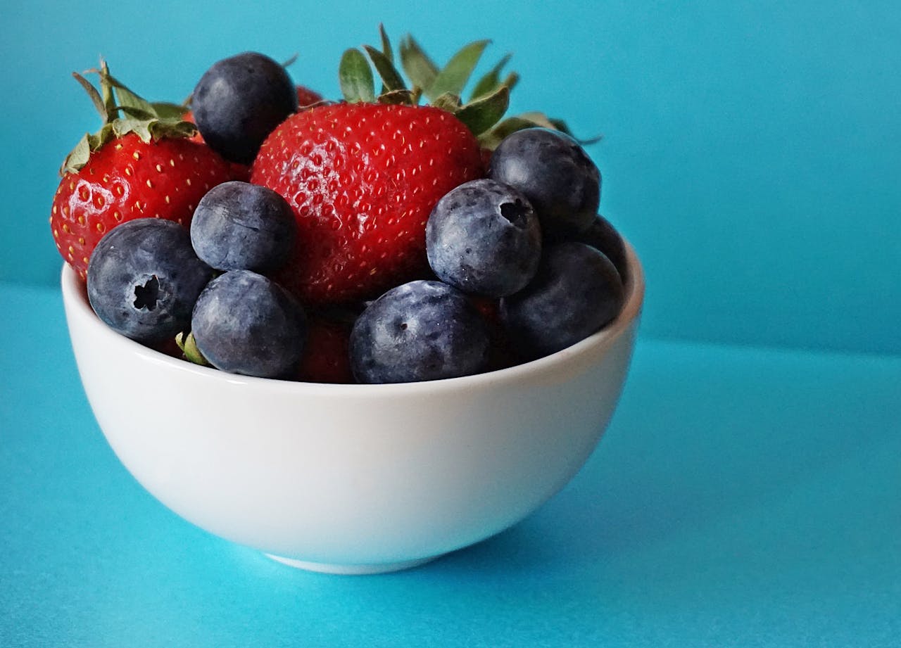 weiße Schale blauer Hintergrund Erdbeeren Blaubeeren Obst & Gemüse in der Kunst